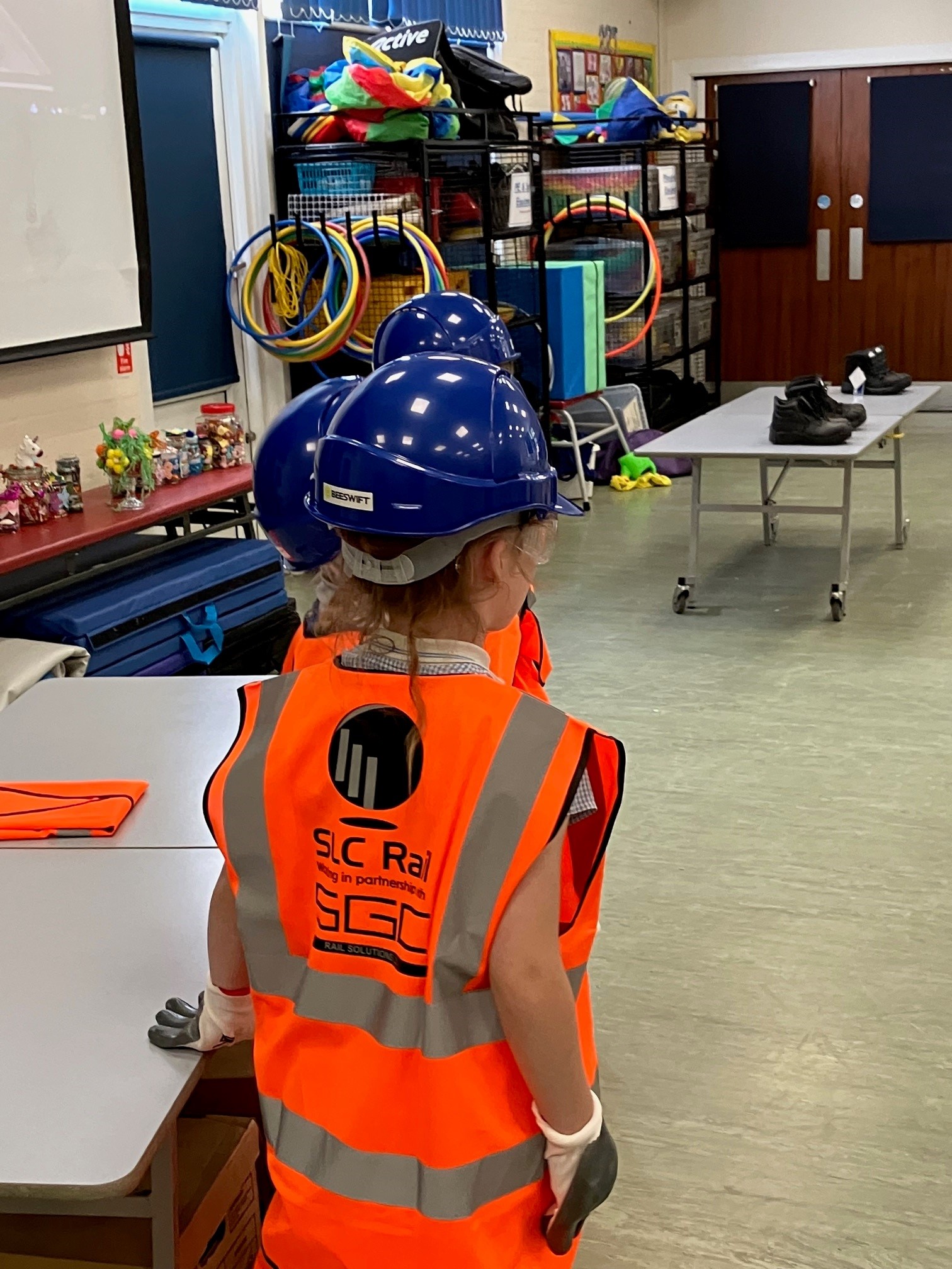 Image description: Above children enjoyed the chance to try on Personal Protective Equipment (PPE).